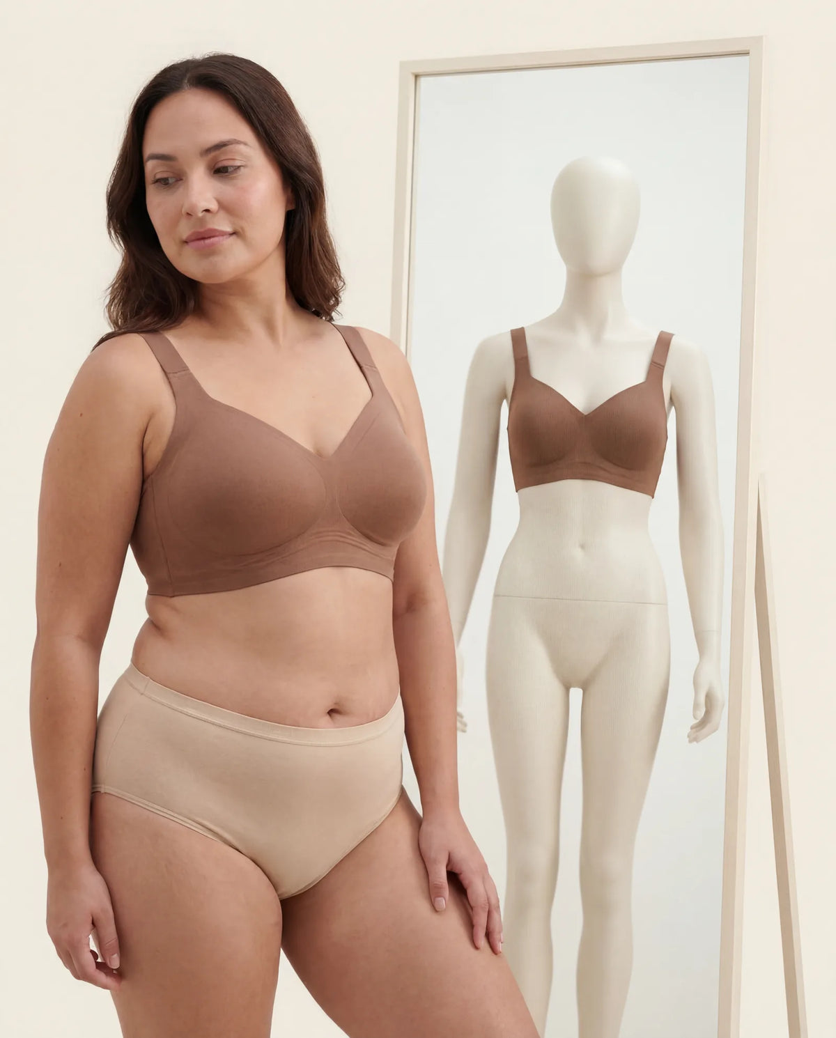 Plus-size woman wearing Leishape Jelly Bra in front of mirror reflecting a generic size-S plastic mannequin